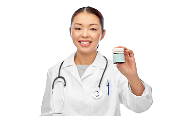 Image showing smiling female doctor holding jar of medicine