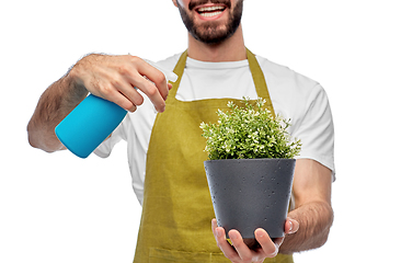 Image showing happy gardener or farmer with sprayer and flower