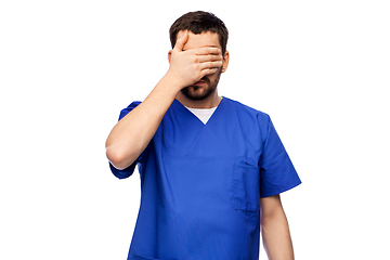 Image showing tired doctor or male nurse covering eyes with hand