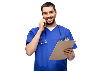 Image showing smiling doctor or male nurse calling on smartphone