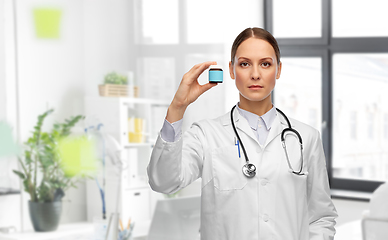 Image showing female doctor holding jar of medicine at hospital