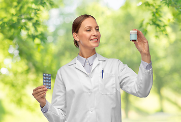 Image showing smiling female doctor holding medicine pills