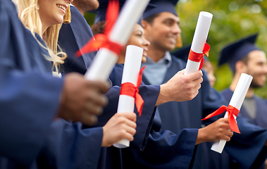 Image showing graduate students in mortar boards with diplomas