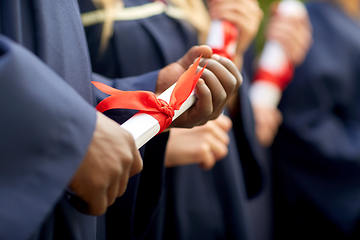 Image showing graduate students in mortar boards with diplomas