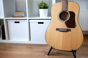 Image showing close up of acoustic guitar on stand at home