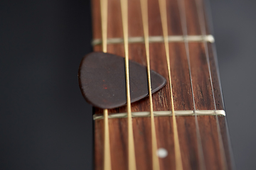 Image showing close up of guitar neck with pick between strings