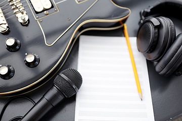 Image showing close up of guitar, music book and headphones