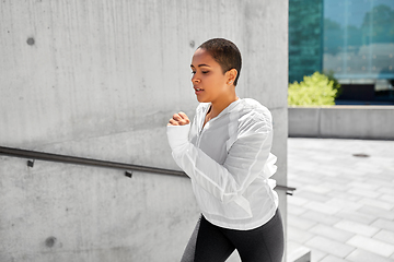 Image showing african american woman running upstairs outdoors