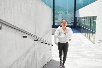 Image showing african american woman running upstairs outdoors