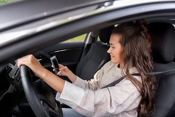 Image showing smiling woman or female driver driving car in city