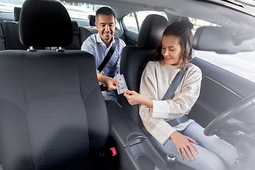 Image showing female car driver taking money from passenger