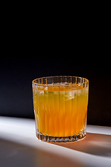 Image showing glass of orange juice with ice on table