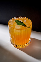 Image showing glass of orange juice with ice on table