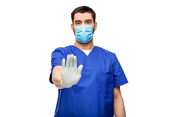 Image showing male doctor in blue uniform and mask showing stop