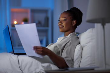 Image showing woman with laptop working in bed at night