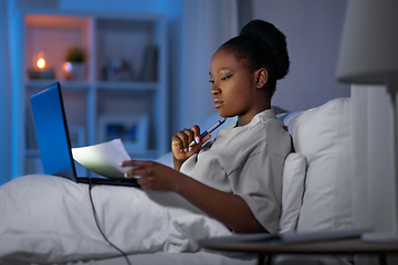 Image showing woman with laptop working in bed at night