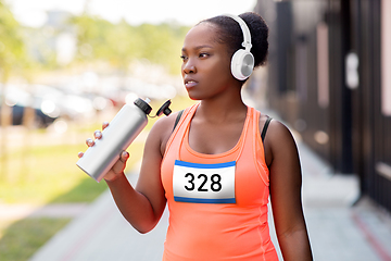 Image showing african female marathon runner drinking water