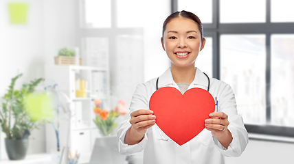 Image showing smiling asian female doctor holding red heart