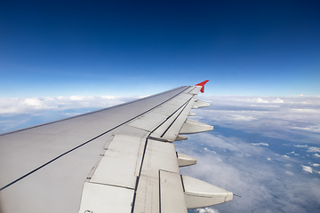 Image showing Wing of an airplane flying above the clouds.