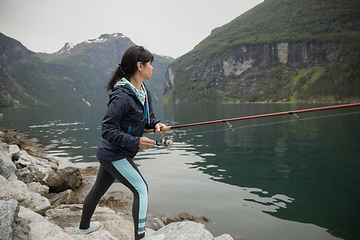 Image showing Woman fishing on Fishing rod spinning in Norway.