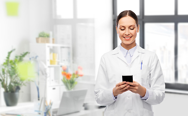 Image showing happy female doctor with smartphone at hospital