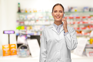 Image showing female doctoror calling on smartphone at pharmacy