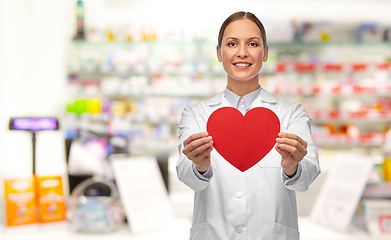 Image showing smiling female doctor with heart at pharmacy