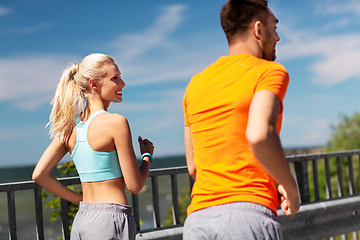 Image showing happy young couple running at seaside in summer