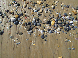 Image showing Wet sea pebbles on the sand