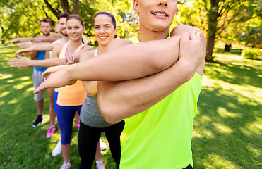 Image showing happy people exercising with trainer at park