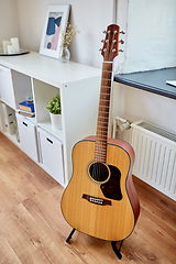 Image showing close up of acoustic guitar on stand at home