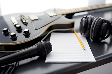 Image showing close up of guitar, music book and headphones