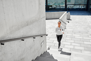 Image showing african american woman running upstairs outdoors