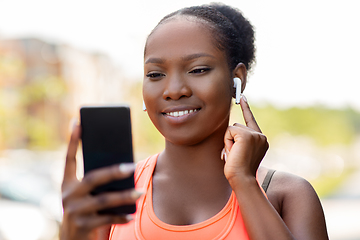 Image showing african american woman with earphones and phone