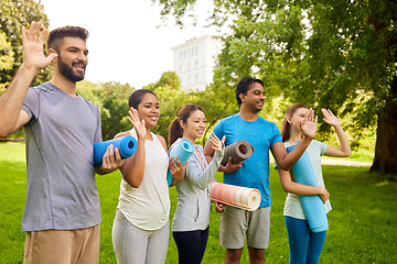 Image showing group of happy people with yoga mats at park