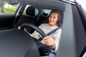 Image showing smiling woman or female driver driving car in city