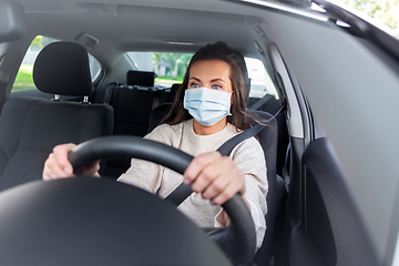 Image showing woman or female driver in mask driving car in city