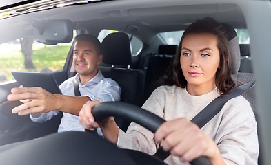 Image showing woman and driving school instructor in car