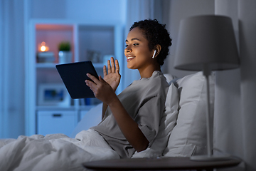 Image showing woman with tablet pc in bed has video call