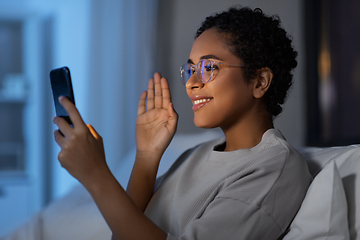 Image showing woman with phone having video call in bed at night