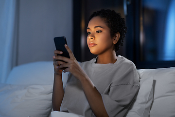 Image showing african woman with smartphone in bed at night