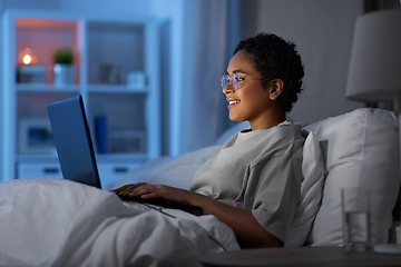 Image showing woman with laptop in bed at home at night