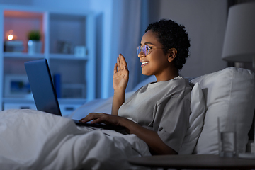 Image showing woman having video call on laptop in bed at night