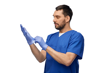 Image showing doctor or male nurse putting medical gloves on