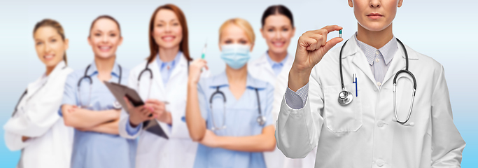 Image showing close up of female doctor holding medicine pill