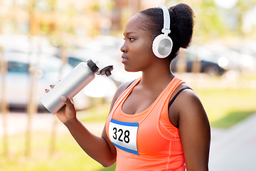 Image showing african female marathon runner drinking water