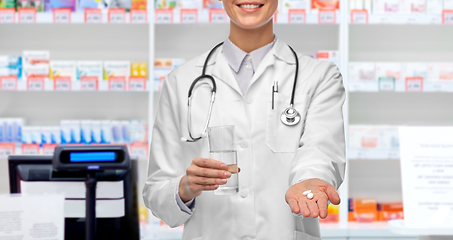 Image showing female doctor with medicine and water at pharmacy