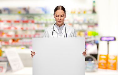 Image showing female doctor holding white board at pharmacy