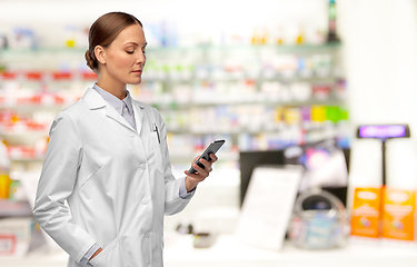 Image showing female doctor with smartphone at pharmacy