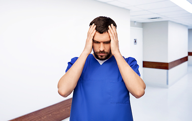 Image showing stressed doctor or male nurse in blue uniform